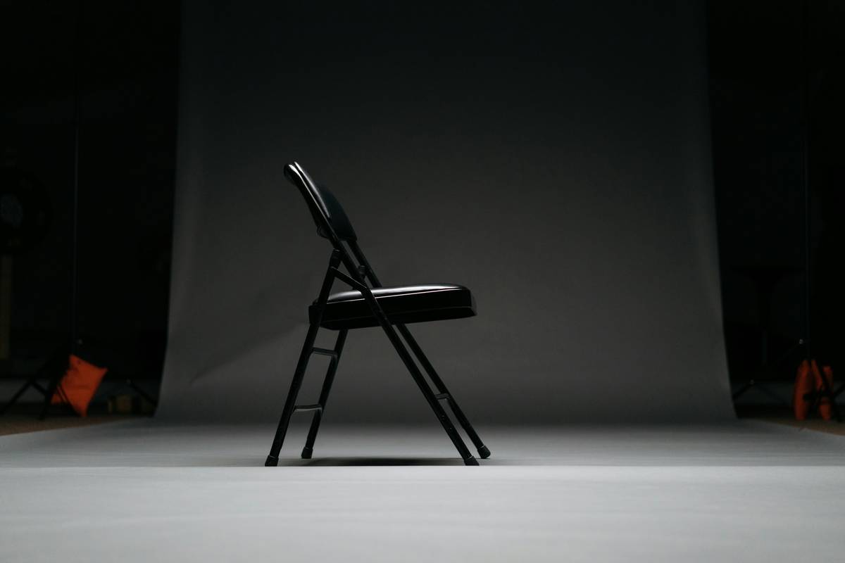 foldable furniture for small living showing a compact wall-mounted folding desk deployed next to a slim sofa bed in a sunlit studio apartment